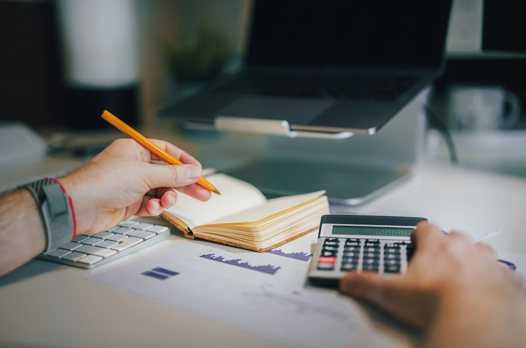 person using calculator for budget